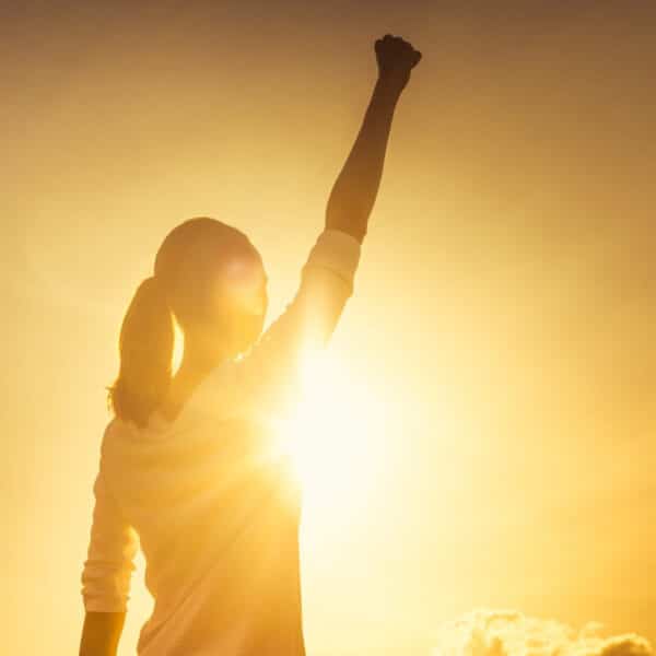 woman raising hand in victory